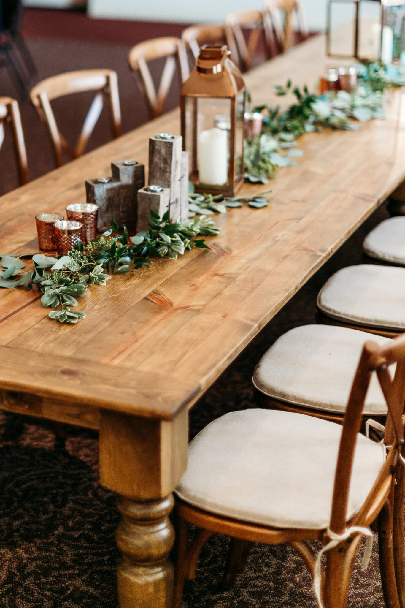 Wooden long table and dining chair with candles and leaves as decorations