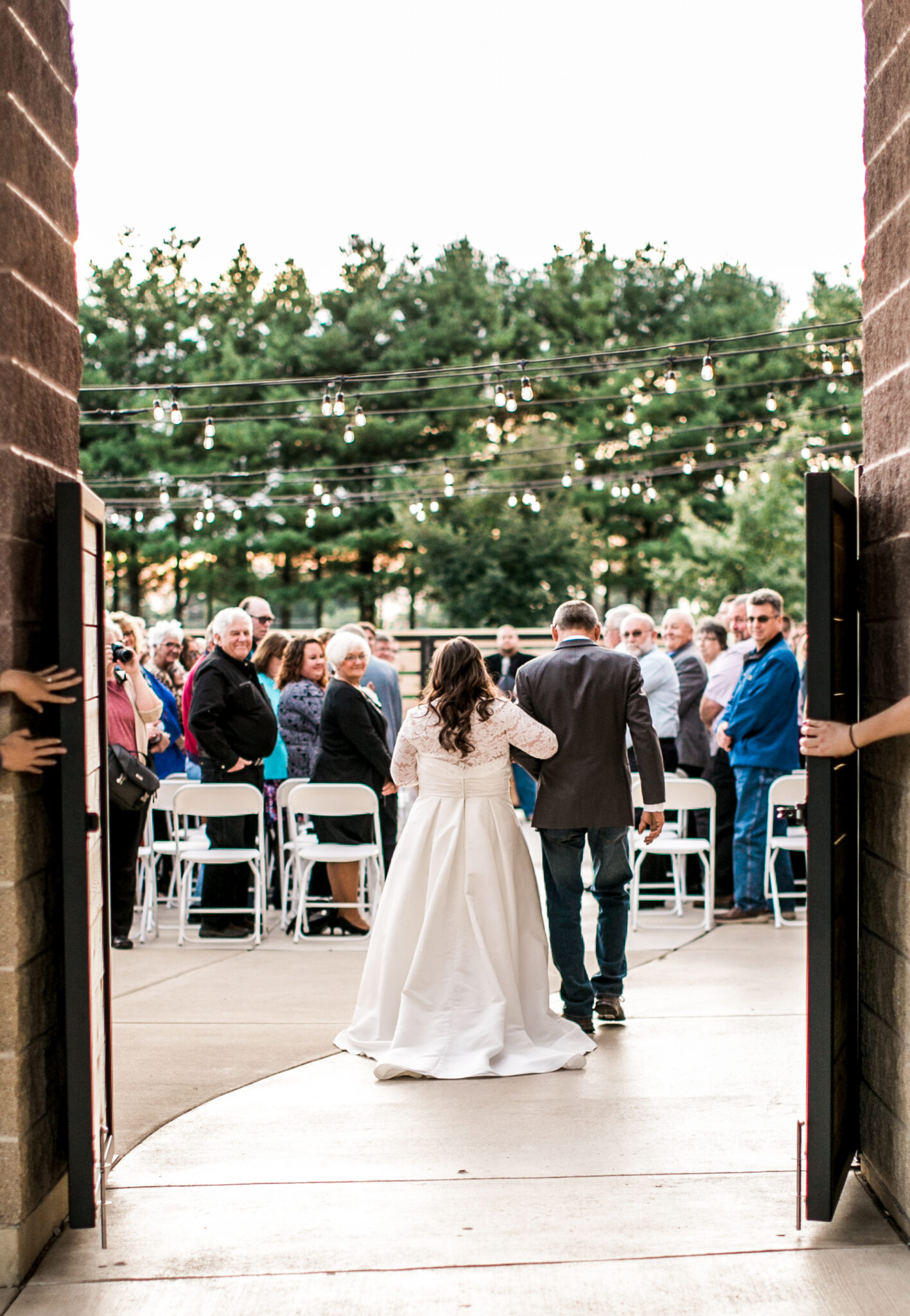 Bride and her escort walking down the aisle during an outdoor wedding ceremony